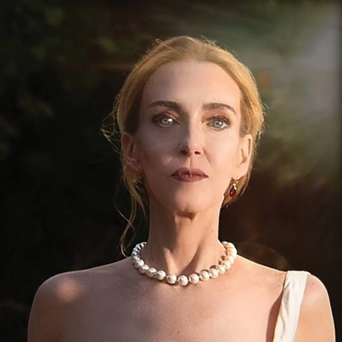 Portrait of Lise Liddell in a white gown and pearls.